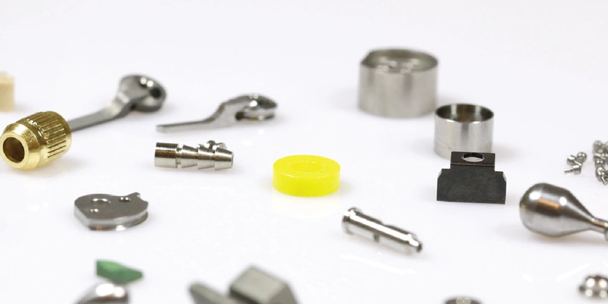 Various small mechanical parts laid out on a white surface.