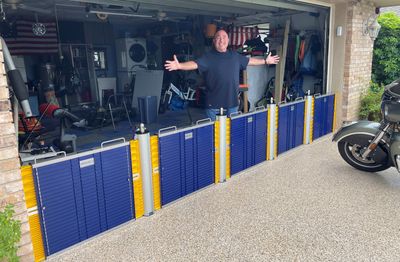 Man standing behind a blue and yellow barrier in a garage.