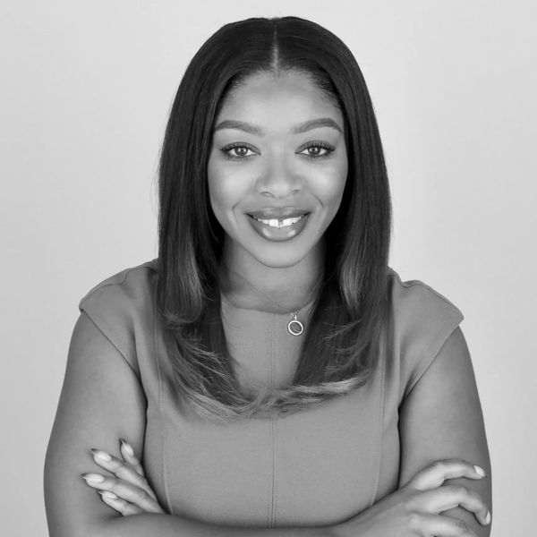 Confident woman with crossed arms smiling at the camera.