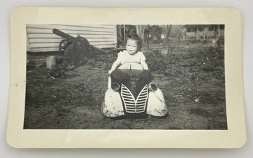Child sitting in a toy car.