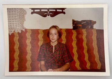 A young girl is sitting on a couch.