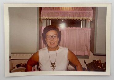 A women in a kitchen smiling at the camera.