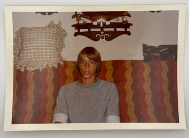 A teenage boy is sitting on a couch.