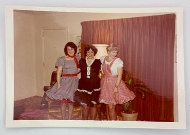 Three women are square-dancing outfits.