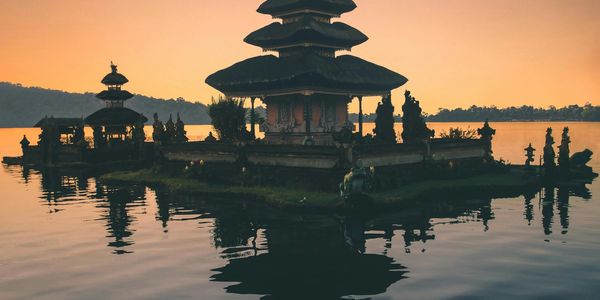 Temple silhouette on water at sunset.