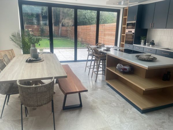 Modern kitchen and dining area with large sliding glass doors to a garden.