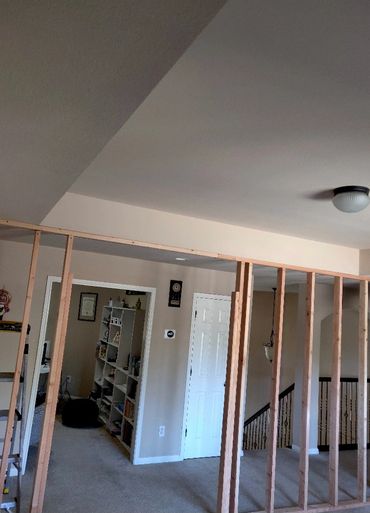 Interior room with partially constructed wooden framing for a wall.