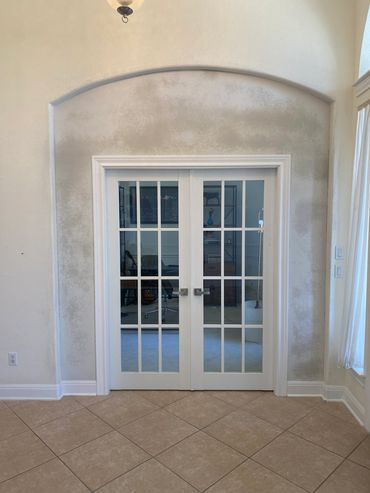 White double glass doors with visible mold or mildew stains around the archway.