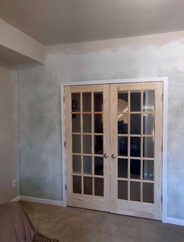 Unfinished room with French doors and partially painted walls.