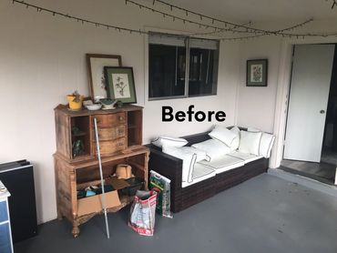 A cluttered patio with old furniture and bags before cleaning.