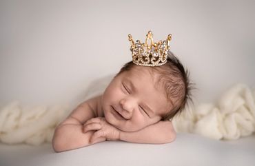 Happy baby sleeping, with crown on head