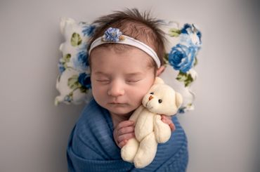 baby sleeping, holding teddy bear