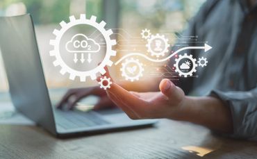 Person using laptop with digital carbon footprint and sustainability icons.