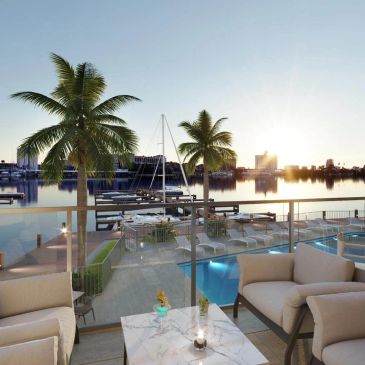 Scenic waterfront patio with palm trees and boats during sunset.
