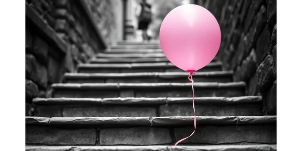 A pink balloon floating on stone steps