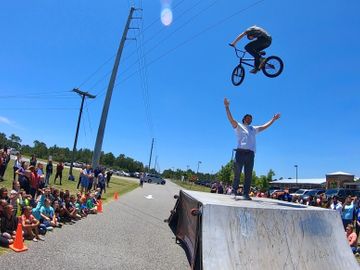 Riley Jordan jumping over the Principle at one the BMX Trickstars educational school assemblies.