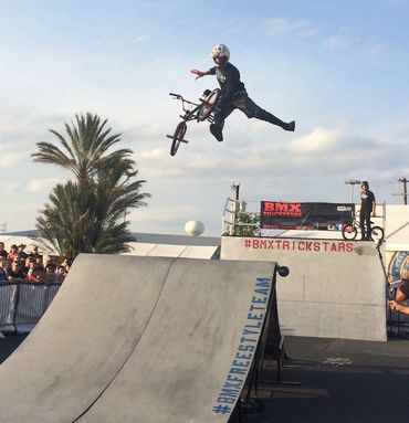 Rob Nolli with the BMX Trickstars performing a 1 handed tail whip over the Box Jump at the San Anton