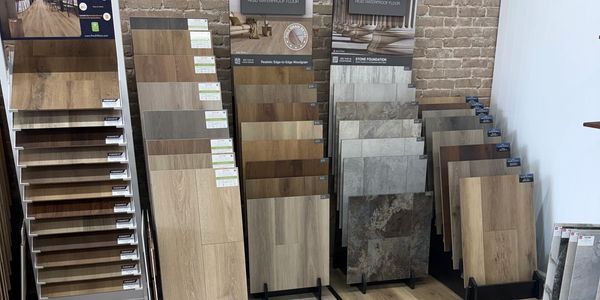 Display of various wood and laminate flooring samples in a store.