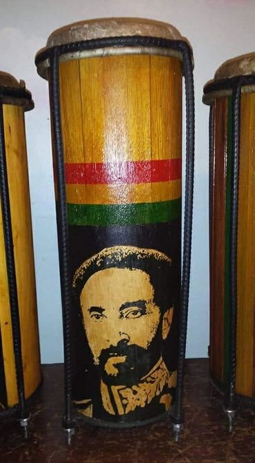 Wooden drum featuring a portrait and Rastafarian colors.