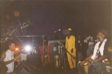 Musicians and audience enjoying a live performance with drumming and clapping.