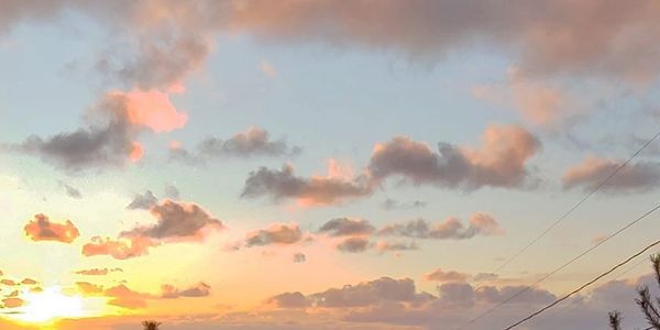 Sunset sky with scattered clouds and warm hues.