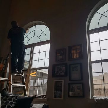 Picture of installer tinting a half moon window inside a home