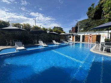 Empty poolside with lounge chairs and umbrellas on a sunny day.