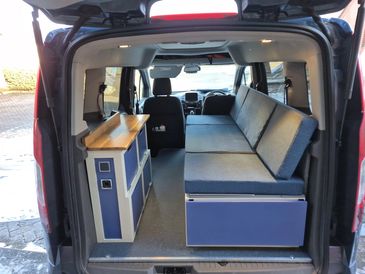 Interior of a camper van with seating and storage space.