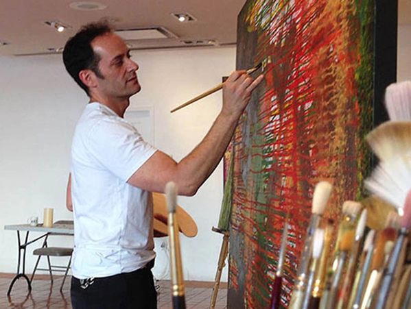A man painting an art holding paint brush