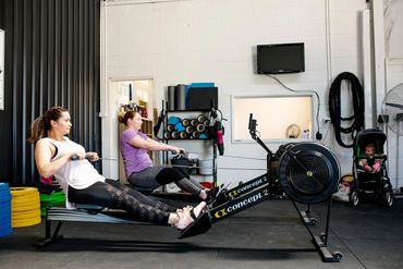 Mums on the rowing machine doing group fitness class