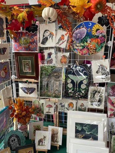 Display of various animal and nature-themed artworks at an art stall.