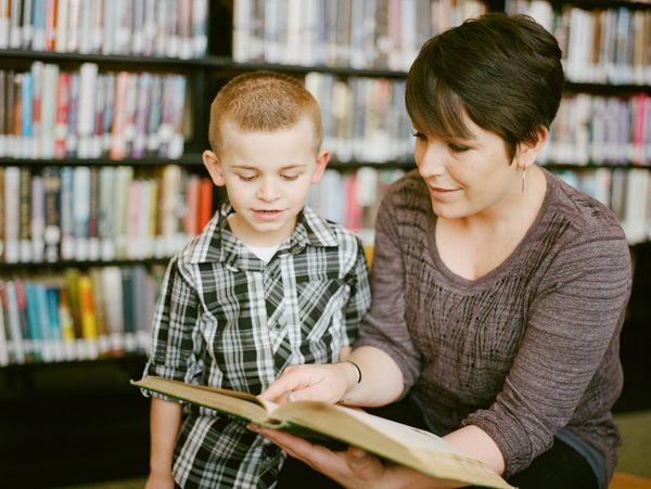 A kindergarten teacher with a student in a small classroom.