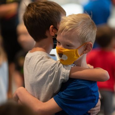 Two friends in kindergarten hugging.