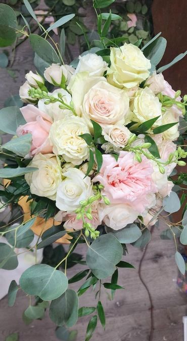 Elegant bouquet of pale pink and white roses with green foliage.
