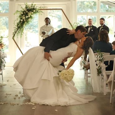 Bride and groom share a romantic kiss during their wedding ceremony.