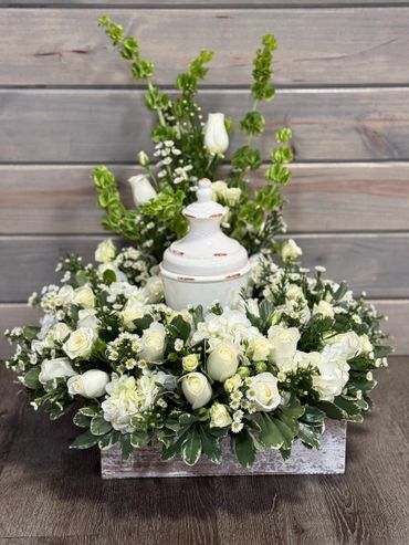 Elegant white floral arrangement with a rustic ceramic urn centerpiece.