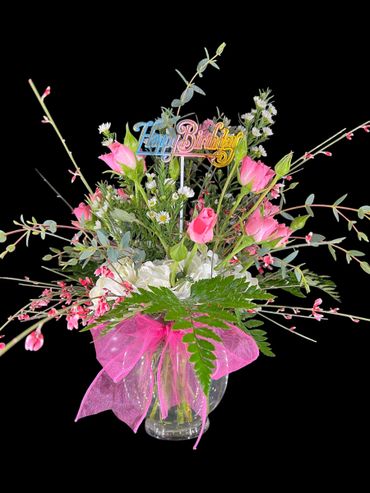 Colorful birthday bouquet with pink roses and a pink ribbon bow.