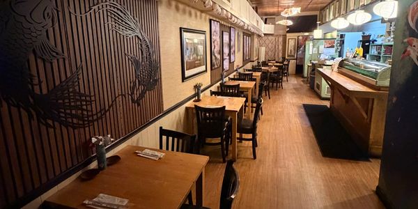 Cozy restaurant with wooden tables and wall art.