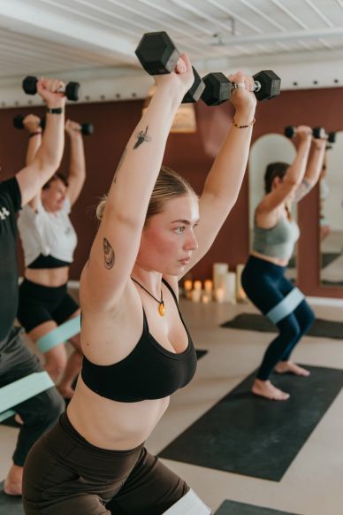 Group workout session lifting dumbbells.