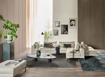 Modulaire elementen bank met losse speelse rugkussens in een lichte stof en op pootjes