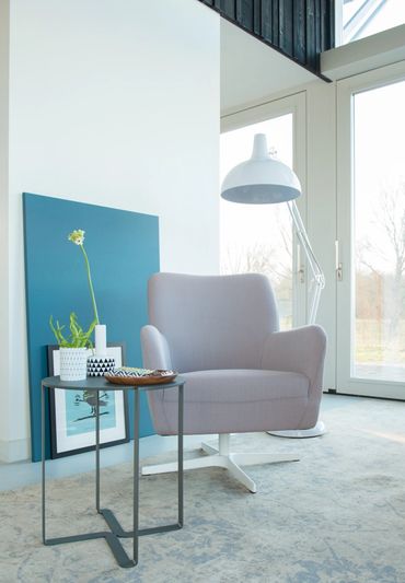Uitnodigende Bolero fauteuil in zachte grijze stof, perfect voor een leeshoek