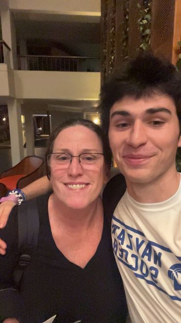 Two people smiling and posing for a selfie indoors.