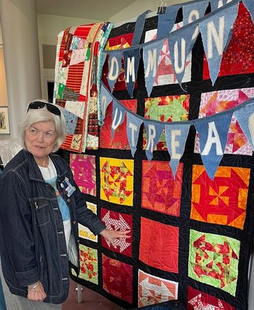 Mary Lee Welling with finished quilts