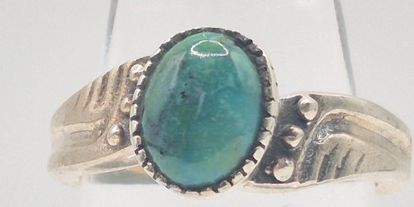 Silver ring with an oval turquoise gemstone.