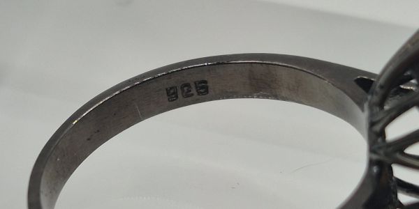 Close-up of a ring band with '925' stamp.