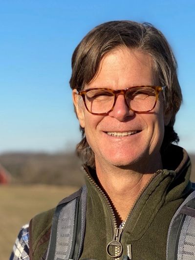 Tod Wickersham smiling with a red barn in the background