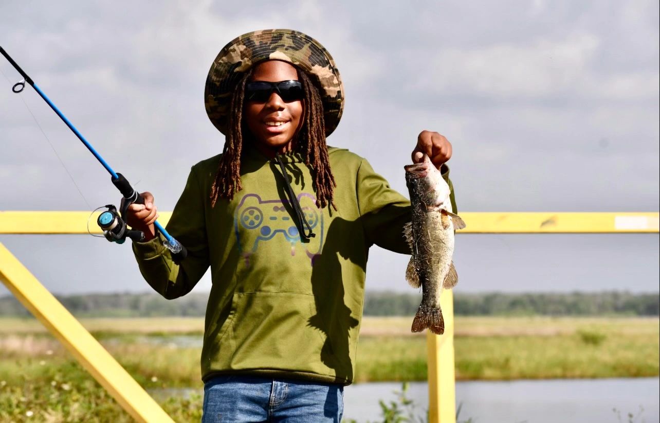 Child holding fish he just caught.