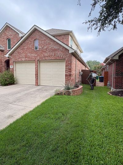 Green & Safe Pest Control technician spraying a home's exterior; pest control serving Westlake, TX