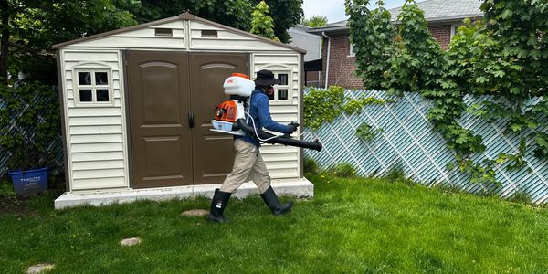 BuzzSkito technician applying eco-friendly mosquito spray in a Mississauga backyard.