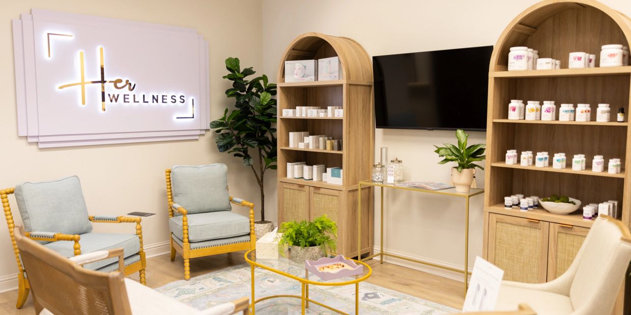 Cozy wellness lounge with comfortable seating and product shelves.